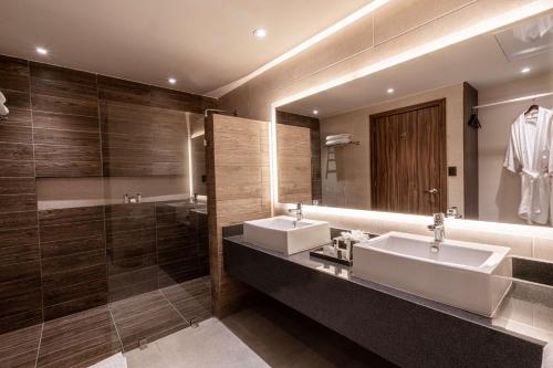 a bathroom with two sinks and a large mirror at Best Western Plus Riviera Veracruz in Veracruz