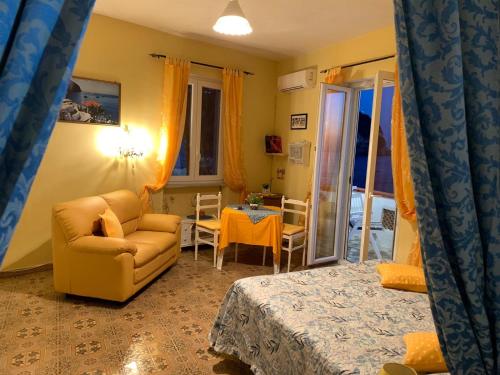 a living room with a couch and a chair and a table at Appartamenti Tina in Villa Restituta in Ischia