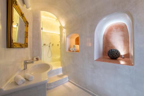 a white bathroom with a sink and a mirror at Villa Renos Hotel in Fira