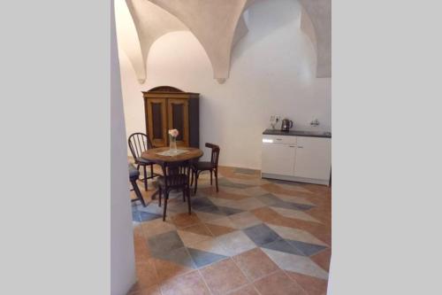 Una cocina y un comedor con mesa y sillas. en Renaissance Vintage Apartment A1, en Telč