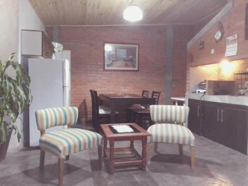 a kitchen with a table and two chairs and a refrigerator at Rinacasaquinchoypile in Paraná