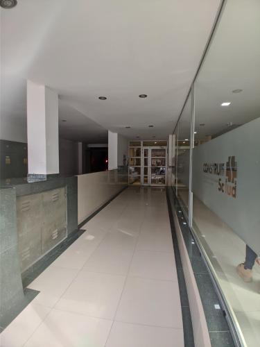 a hallway in a building with a person walking down it at Dolce Casa Departamentos in Neuquén