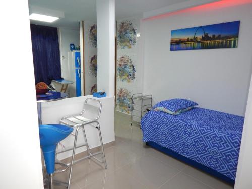a bedroom with a bed and a table and a stool at Delfin 207 in Cartagena de Indias