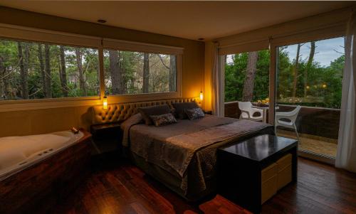 a bedroom with a bed and a large window at Mizu Hotel Boutique in Mar de las Pampas