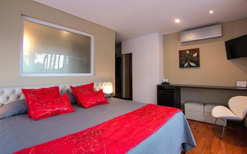 a bedroom with a bed with red pillows at Mizu Hotel Boutique in Mar de las Pampas