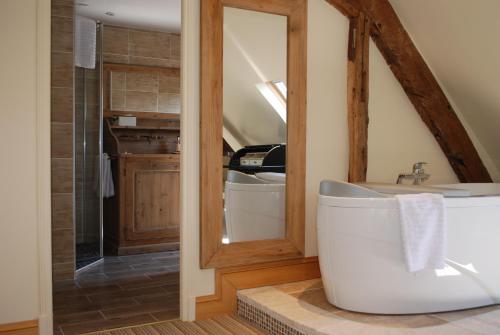 a bathroom with a tub and a sink and a mirror at Auberge du Bon Laboureur Chenonceaux in Chenonceaux