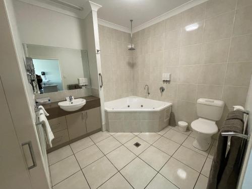 uma casa de banho com uma banheira, um WC e um lavatório. em Emerald Inn em Emerald