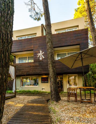 a building with a picnic table in front of it at Mizu Hotel Boutique in Mar de las Pampas