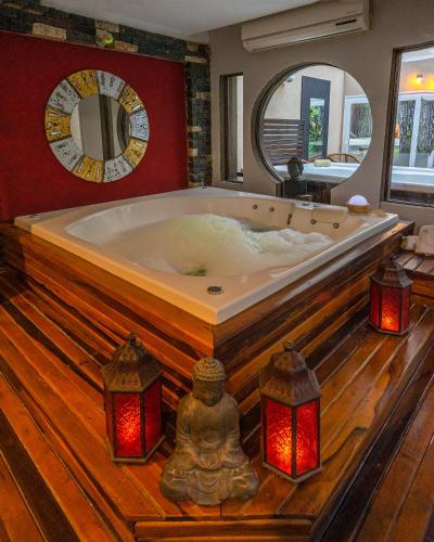 a large bath tub in a room with a large mirror at Mizu Hotel Boutique in Mar de las Pampas