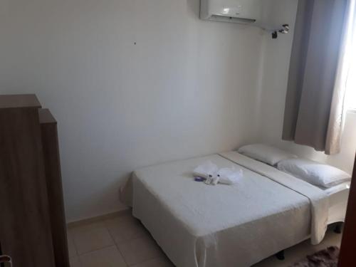 a small bedroom with a bed with white sheets at Apto Oniz Campos X in Campos dos Goytacazes