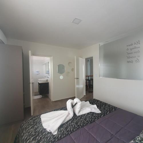a bedroom with a bed with towels on it at BLU APARTMENTS in San Rafael