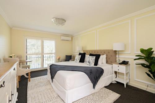 - une chambre avec un grand lit blanc et une fenêtre dans l'établissement Lincoln Downs Resort Batemans Bay, à Batemans Bay