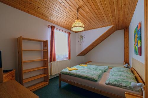 a bedroom with a bed and a wooden ceiling at Horská Kvilda - Ubytování U Chvalů in Horská Kvilda