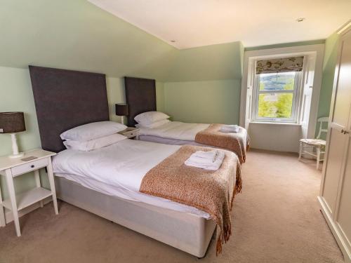 um quarto com 2 camas e uma janela em Rottal Farmhouse em Millton of Clova
