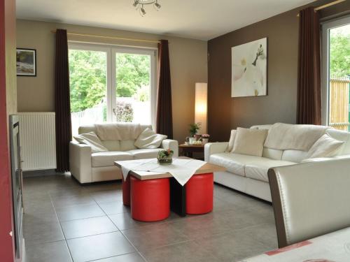 un soggiorno con 2 divani e un tavolo di Nice holiday home in Bomal Durbuy with garden a Bomal