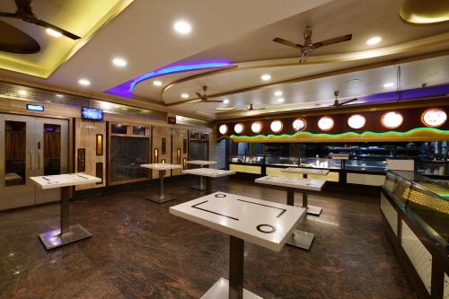 a restaurant with tables in the middle of a room at Hotel BV Colours Bommanahalli in Bangalore