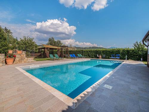 einen Pool mit blauem Wasser im Hof in der Unterkunft Belvilla by OYO Villa Giovanna in Montalcino