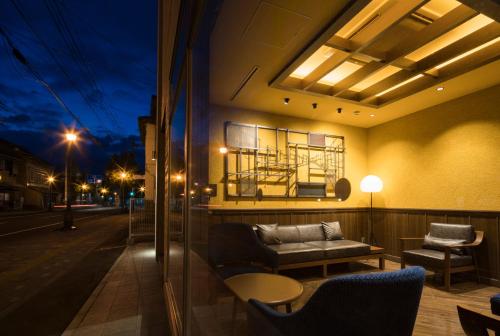 a room with a couch on a balcony at night at Hotel Torifito Otaru Canal in Otaru