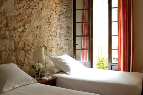 a bedroom with two beds and a stone wall at AinB Las Ramblas-Guardia Apartments in Barcelona