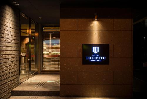 a building with a sign on the side of it at Hotel Torifito Otaru Canal in Otaru
