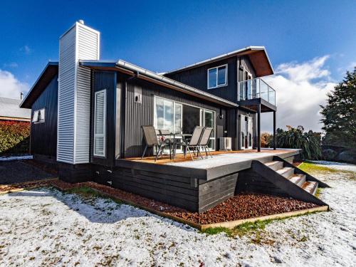 a modular home with a deck and a table at Sunshine and Snow Lodge - Ohakune Holiday Home in Ohakune