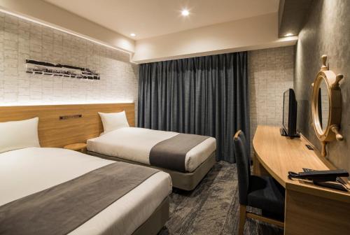 a hotel room with two beds and a desk at Hotel Torifito Otaru Canal in Otaru