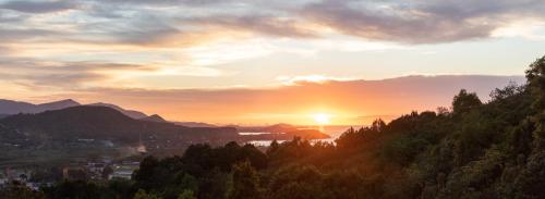 a sunset over a city with trees and a river at Baan Kimsacheva - Seaview Private Villa in Choeng Mon Beach