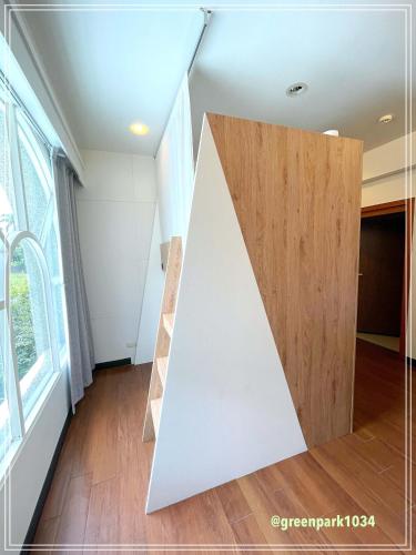 a room with a white wall and a wooden door at Green Park Homestay in Luodong