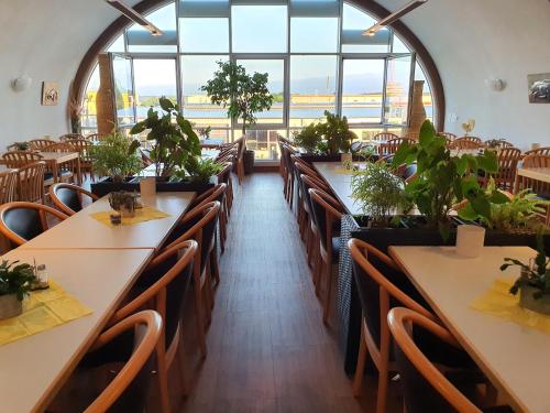 a restaurant with tables and chairs with plants on them at Hotel SunParc - SHUTTLE zum Europa-Park Rust 4km & Rulantica 2km in Ringsheim