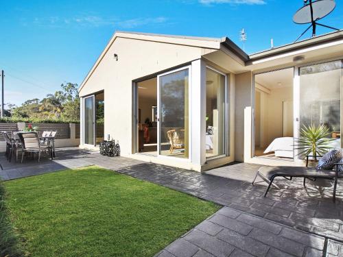 a house with large glass doors and a patio at Saltbush at Vincentia by Experience Jervis Bay in Vincentia