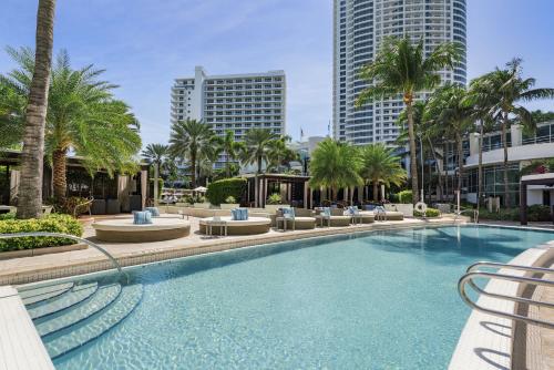 uma grande piscina com palmeiras e edifícios em Studio at Sorrento Residences- FontaineBleau Miami Beach home em Miami Beach