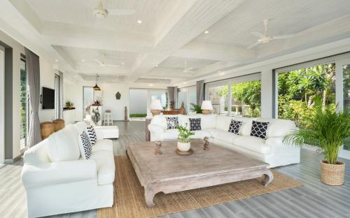 a living room with white furniture and large windows at Baan Kimsacheva - Seaview Private Villa in Choeng Mon Beach