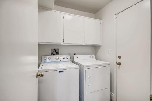 a white kitchen with a stove and a refrigerator at Luxurious House With A Pool, Spa, and Patio, Sleeps 6 Comfortably in Las Vegas