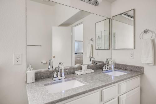 baño con 2 lavabos y espejo grande en Luxurious House With A Pool, Spa, and Patio, Sleeps 6 Comfortably en Las Vegas