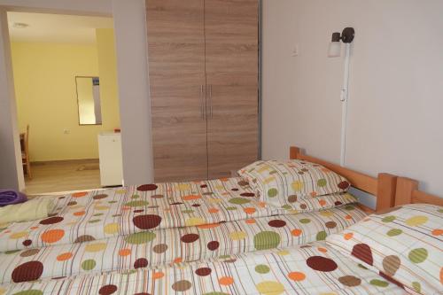 Una cama con un edredón colorido en un dormitorio en Konačište Kovačević en Bajina Bašta