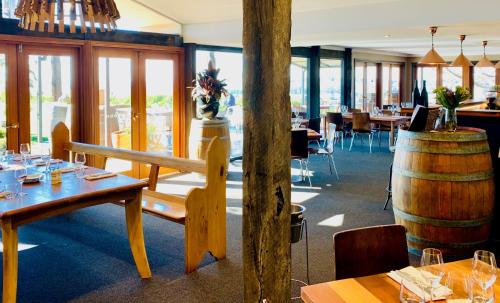 a restaurant with wooden tables and a barrel at Borrodell Vineyard in Orange