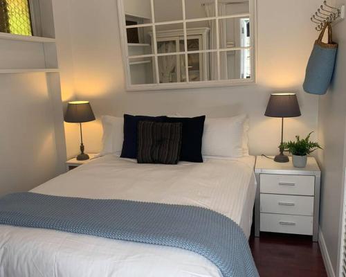 a bedroom with a large white bed with two lamps at Stylish Private Studio, Close to Beach, WIFI, Parking in Melbourne