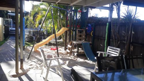 a backyard with a playground with a slide at Maple Villa - The Beach House by the bay in Brisbane