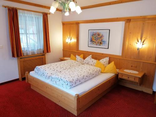 a bedroom with a large wooden bed with yellow pillows at Ferienwohnung Wanger in Aschau