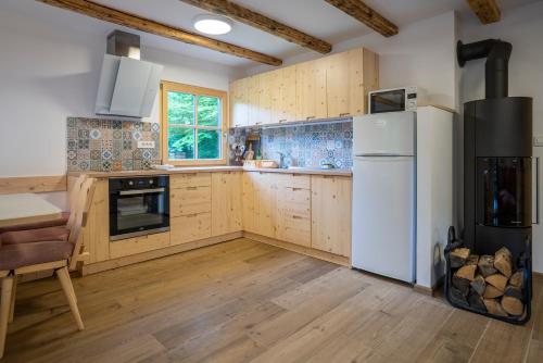 a kitchen with wooden cabinets and a white refrigerator at Chalet TISA in Bohinj