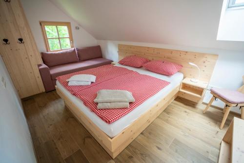 een slaapkamer met een groot bed en een bank bij Chalet TISA in Bohinj