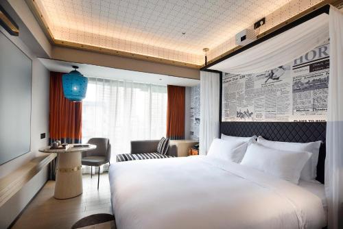a hotel room with a large bed and a table at Arthur Hotel Canton Tower Guangzhou-广州塔骑士物语酒店 in Guangzhou