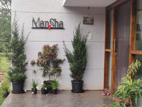 un edificio con macetas y una señal en él en ManSha, en Panchgani