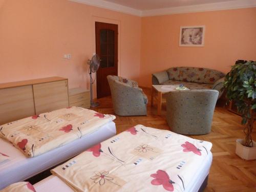 Habitación con 2 camas, mesa y sofá en Dexter, en Teplice