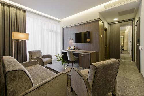 a hotel room with chairs and a desk and a television at Congress Avenue Hotel in Vilnius