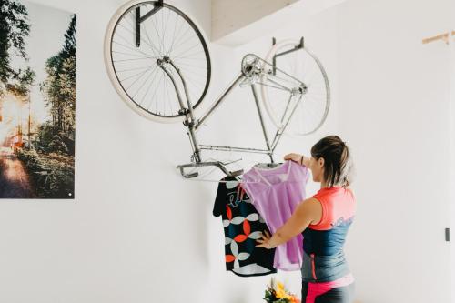 a woman looking at a bike hanging on a wall at La Tana del Lupo B&B, family and outdoor sports in Borgo
