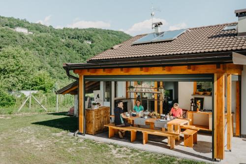 博爾戈的住宿－La Tana del Lupo B&B, family and outdoor sports，坐在房子外桌子上的家庭