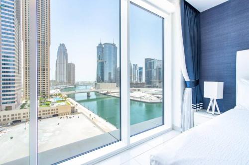 a bedroom with a large window with a view of a city at Modern Luxury in the Heart of Downtown Dubai in Dubai