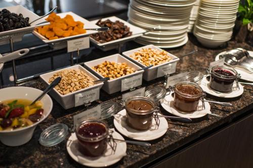 a buffet with bowls of food on a counter at Congress Avenue Hotel in Vilnius