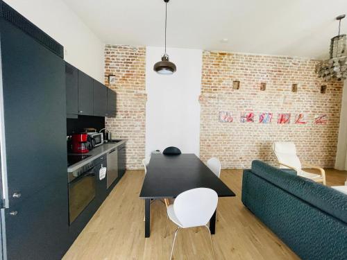eine Küche und ein Wohnzimmer mit einem schwarzen Tisch und Stühlen in der Unterkunft Zentrale ruhige Ferienwohnung in Berlin in Berlin